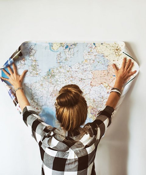 Eine Frau hält eine Europakarte an die Wand